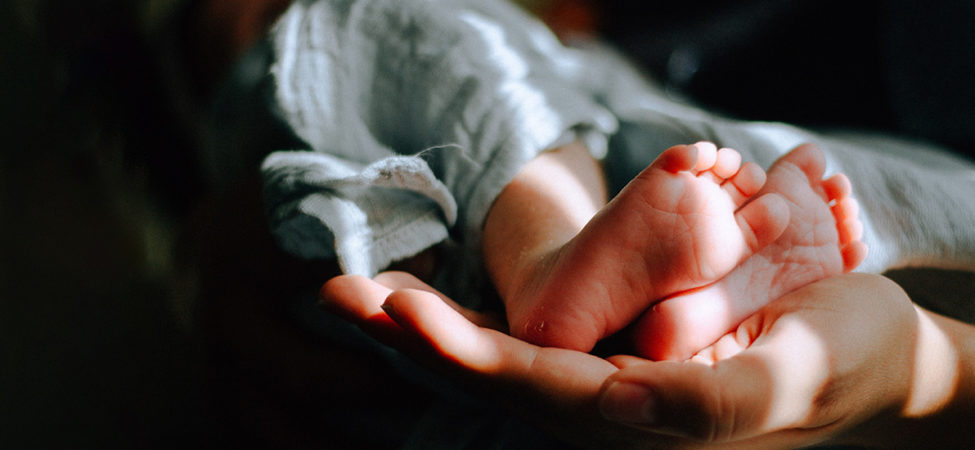 en hånd holder babyføtter