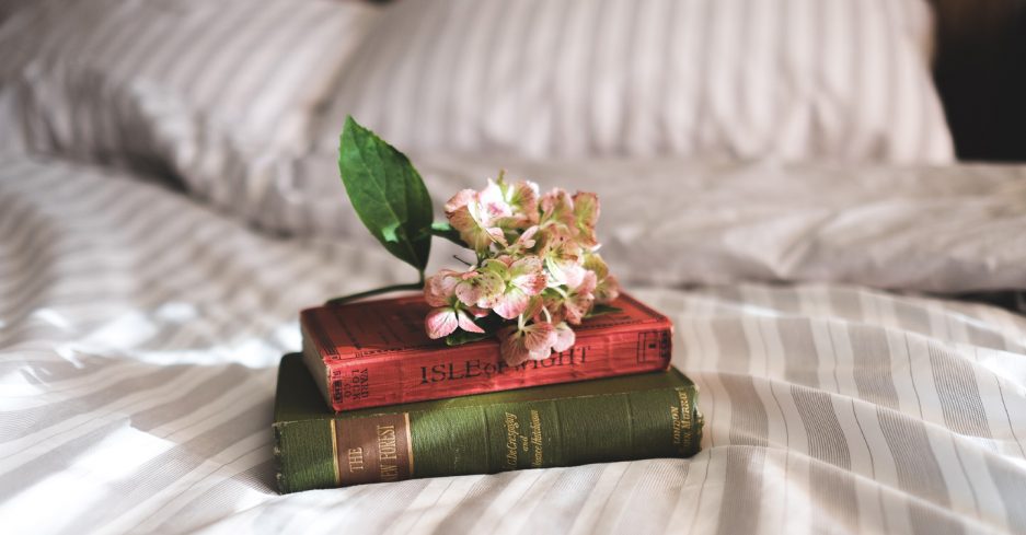 Bøker på en seng med blomst