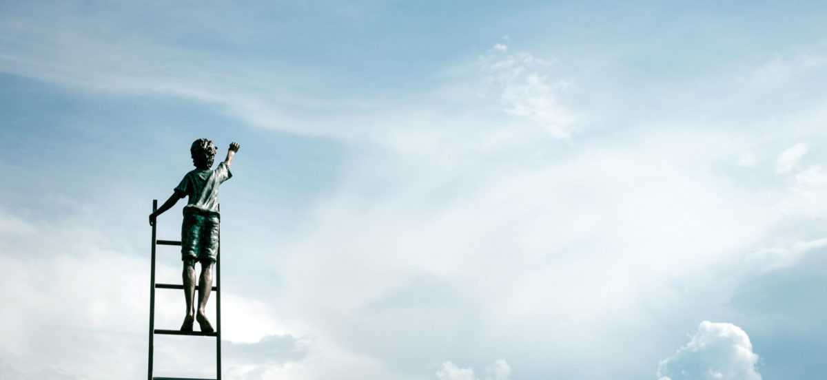 Gutt som står på stige og strekker seg mot himmelen. Illustrasjonsfoto til "Ukas dikt": Olav H. Hauge "Eg siktar litt yver"