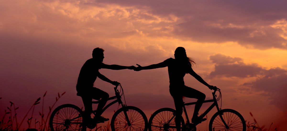 Par på sykler i solnedgang