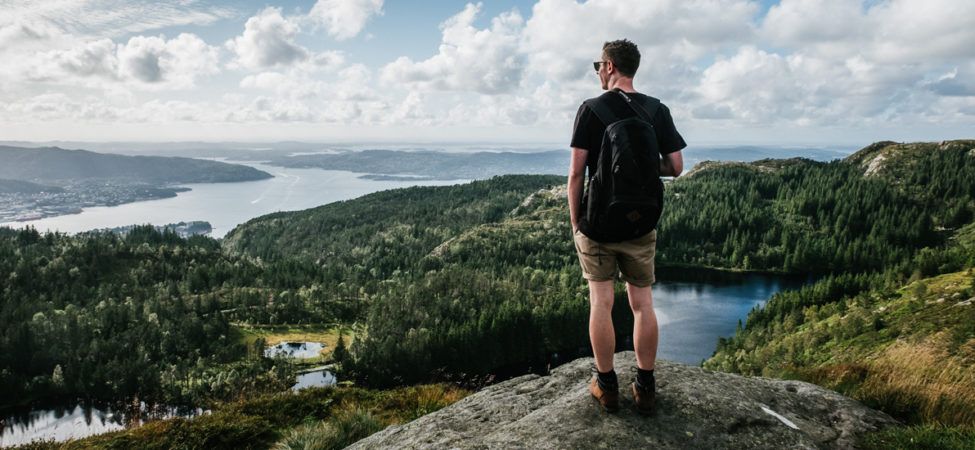 Foto av mann som ser utover fjellheimen