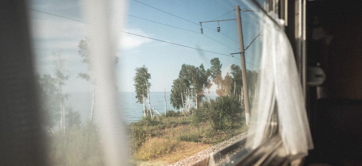 Utsikt fra togvindu med gardiner