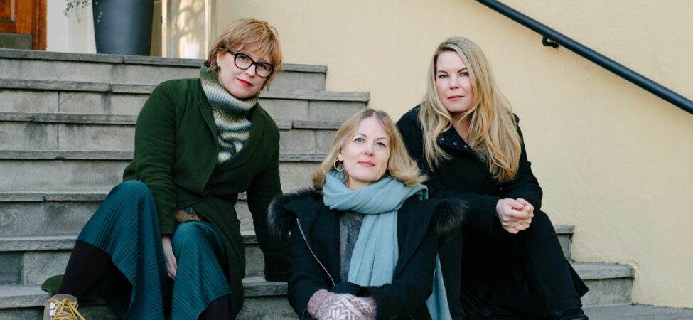 Foto av forfatterne Hilde Østby, Helene Uri og Marta Breen sittende i trapp.
