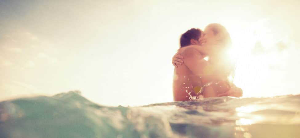 Foto av et par som klemmer hverandre ute i vannet