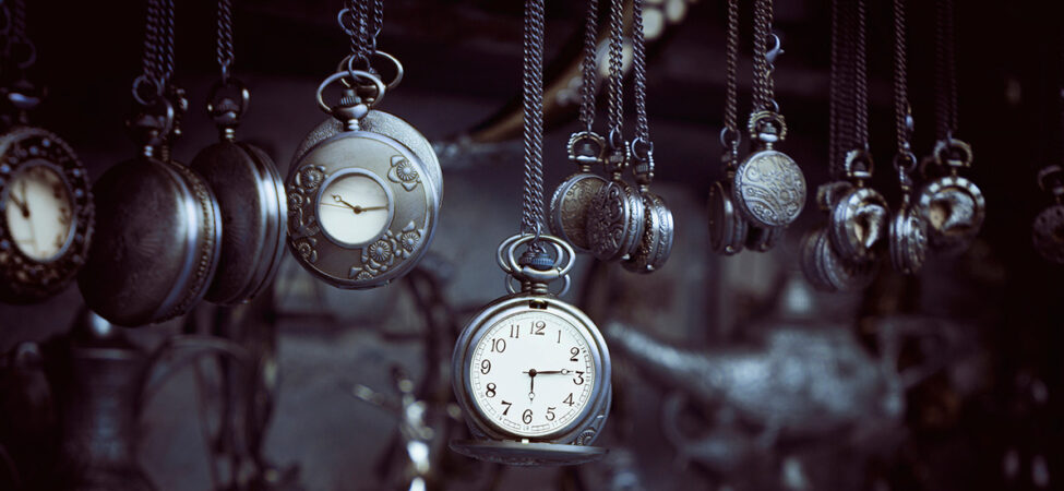Foto av mange gamle klokker som henger på snorer