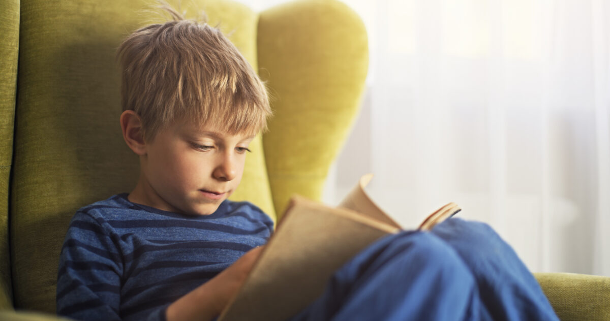 Foto av gutt som er helt oppslukt av de beste bøkene for barn 6-9 år