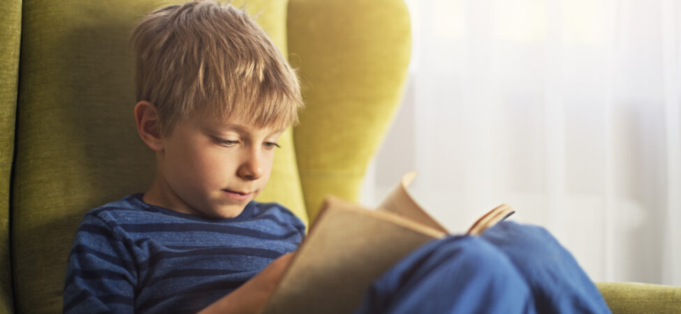 Foto av gutt som er helt oppslukt av de beste bøkene for barn 6-9 år